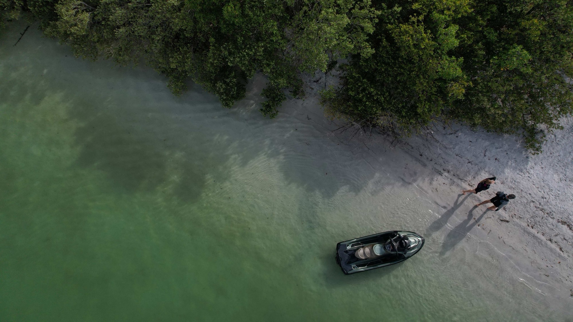Jet-ski Sea-Doo échoué sur une plage de sable blanc aux Antilles, deux personnes à terre